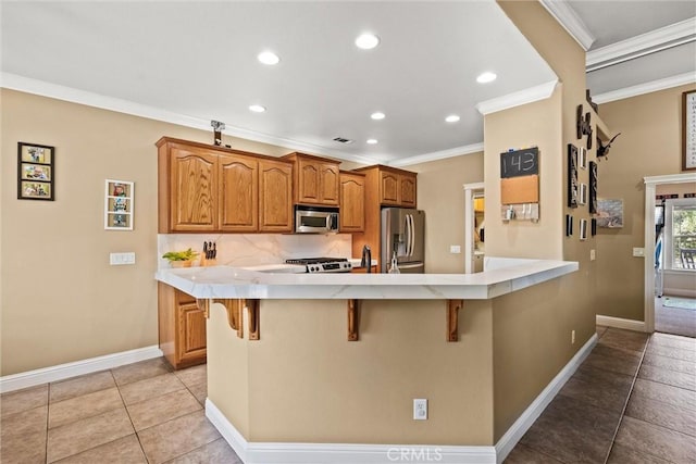 14690 Paynes Creek Rd, Red Bluff, CA 96080 - kitchen with appliances with stainless steel finishes, a breakfast bar area, crown molding, a peninsula, and baseboards