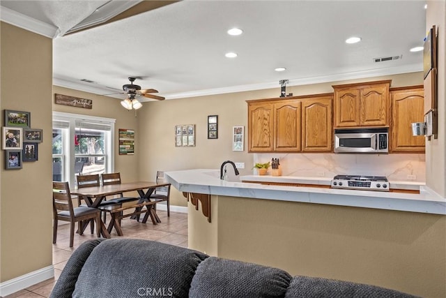 14690 Paynes Creek Rd, Red Bluff, CA 96080 - kitchen with stainless steel microwave, ornamental molding, range, light tile patterned floors, and recessed lighting