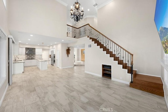 5420 Kodiak Mountain Dr, Yorba Linda, CA 92887 - unfurnished living room featuring stairs, a towering ceiling, a chandelier, crown molding, and light marble finish floors