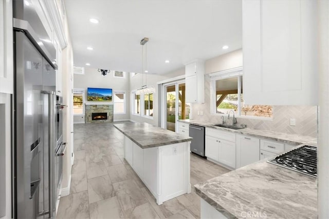 5420 Kodiak Mountain Dr, Yorba Linda, CA 92887 - kitchen featuring appliances with stainless steel finishes, a kitchen island, open floor plan, light stone countertops, and recessed lighting