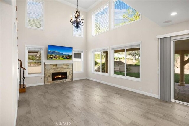 5420 Kodiak Mountain Dr, Yorba Linda, CA 92887 - unfurnished living room with healthy amount of natural light, a chandelier, a tiled fireplace, and a high ceiling