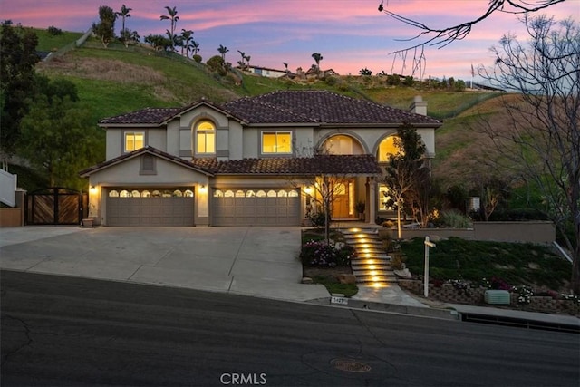 5420 Kodiak Mountain Dr, Yorba Linda, CA 92887 - mediterranean / spanish home with stucco siding, concrete driveway, a chimney, and a gate