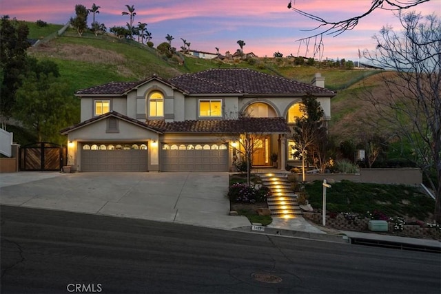 5420 Kodiak Mountain Dr, Yorba Linda, CA 92887 - mediterranean / spanish home featuring stucco siding, concrete driveway, a chimney, a gate, and an attached garage