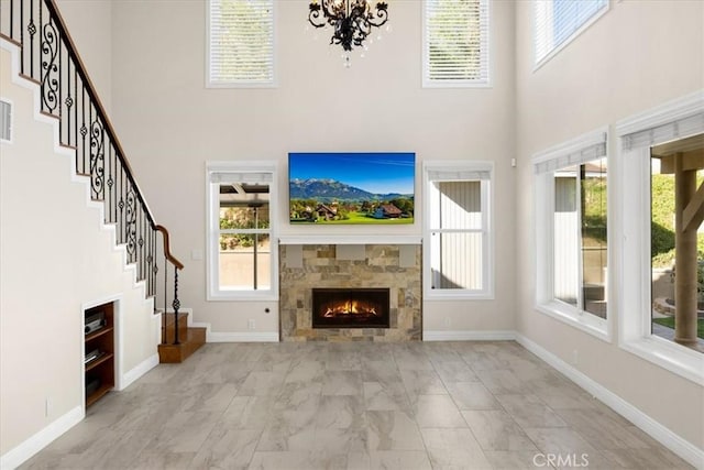 5420 Kodiak Mountain Dr, Yorba Linda, CA 92887 - unfurnished living room with a towering ceiling, marble look tile flooring, a tiled fireplace, stairs, and a chandelier
