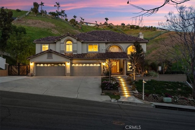 5420 Kodiak Mountain Dr, Yorba Linda, CA 92887 - mediterranean / spanish-style home with stucco siding, concrete driveway, a chimney, a gate, and a garage