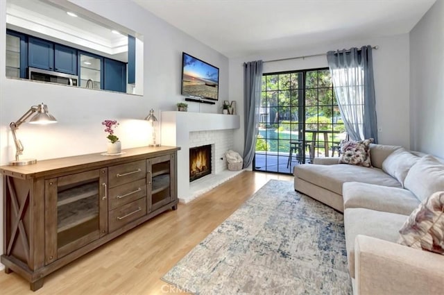 20122 Bayfront Ln Unit 102, Huntington Beach, CA 92646 - living area featuring light wood-style flooring and a brick fireplace