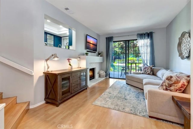 20122 Bayfront Ln Unit 102, Huntington Beach, CA 92646 - living area featuring wood finished floors, stairway, a warm lit fireplace, and recessed lighting