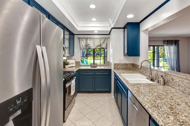 20122 Bayfront Ln Unit 102, Huntington Beach, CA 92646 - kitchen with appliances with stainless steel finishes, blue cabinets, crown molding, a sink, and light tile patterned flooring