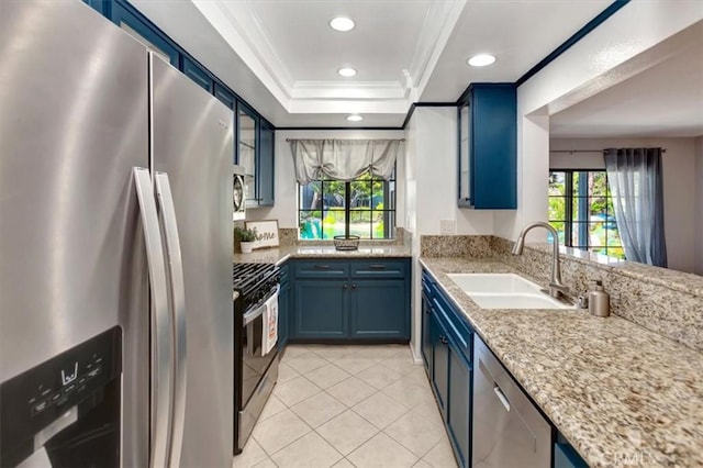 20122 Bayfront Ln Unit 102, Huntington Beach, CA 92646 - kitchen with appliances with stainless steel finishes, blue cabinetry, ornamental molding, light tile patterned flooring, and healthy amount of natural light