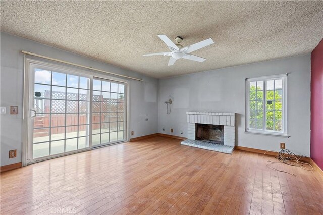 1945 Cumberland Dr, West Covina, CA 91792 - unfurnished living room featuring wood-type flooring, a textured ceiling, ceiling fan, a brick fireplace, and baseboards