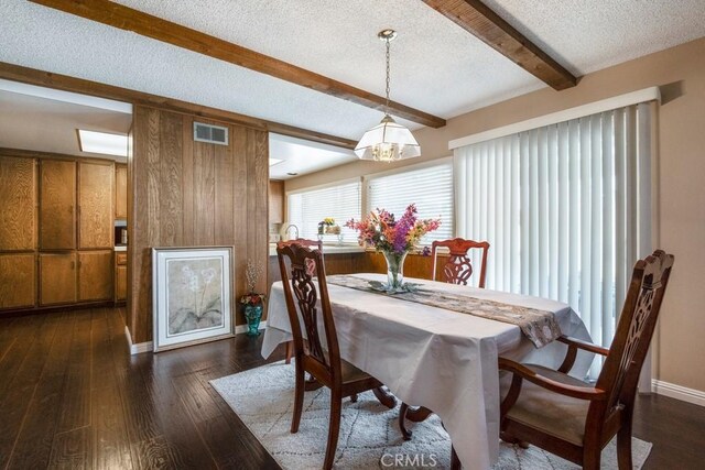4734 E Tanglewood Ave, Anaheim, CA 92807 - dining area featuring beam ceiling, dark wood-style floors, a textured ceiling, a chandelier, and baseboards