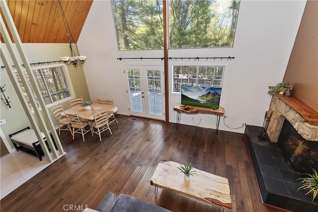 27476 School Rd, Lake Arrowhead, CA 92326 - entryway featuring french doors, hardwood / wood-style flooring, a chandelier, high vaulted ceiling, and a stone fireplace