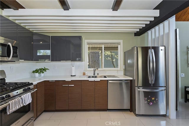 27476 School Rd, Lake Arrowhead, CA 92326 - kitchen with stainless steel appliances, light countertops, backsplash, light tile patterned floors, and beam ceiling