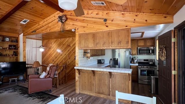 33477 Fern Dr, Green Valley Lake, CA 92341 - kitchen featuring appliances with stainless steel finishes, tile counters, wood ceiling, wood finished floors, and a peninsula