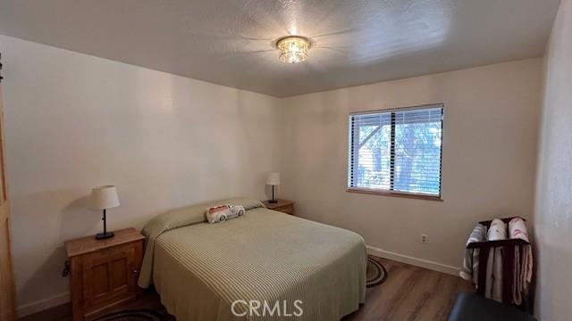 33477 Fern Dr, Green Valley Lake, CA 92341 - bedroom with baseboards and wood finished floors