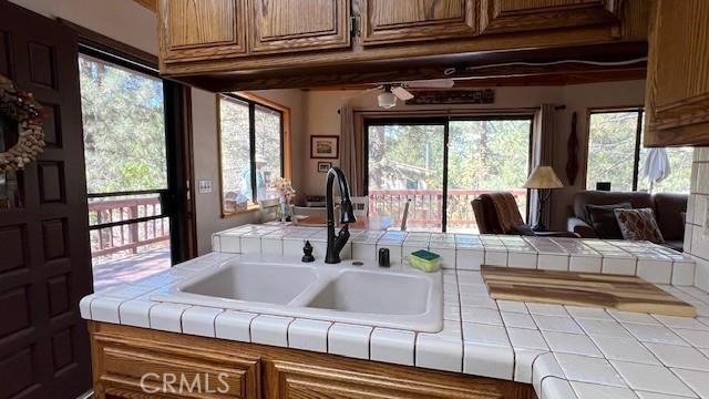 33477 Fern Dr, Green Valley Lake, CA 92341 - kitchen featuring a sink, tile countertops, and brown cabinets
