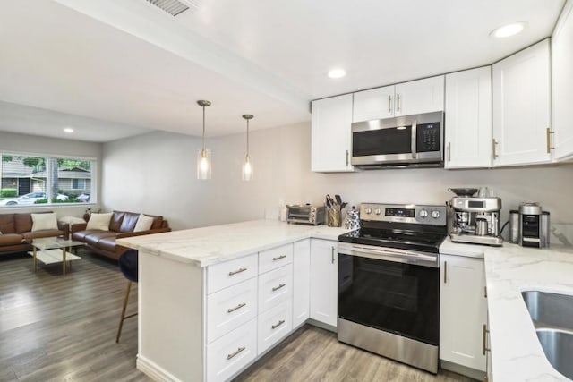951 Amistad Ct Unit C, El Cajon, CA 92019 - kitchen featuring stainless steel appliances, a peninsula, white cabinetry, open floor plan, and wood finished floors
