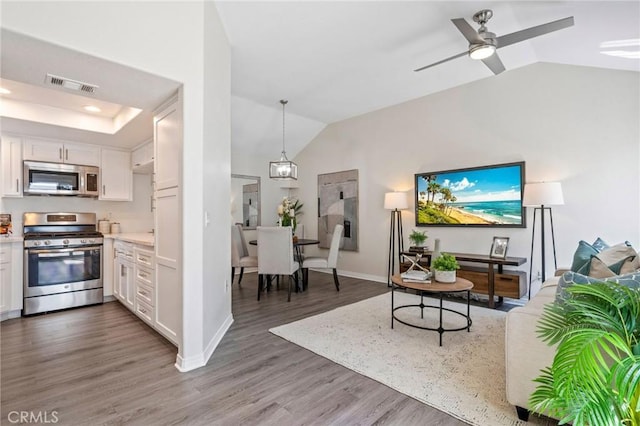 28241 Sorrento Unit 124, Laguna Niguel, CA 92677 - kitchen with stainless steel appliances, lofted ceiling, white cabinets, wood finished floors, and light countertops