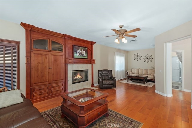29944 Peach Tree Ct, Murrieta, CA 92563 - living room with ceiling fan, light wood finished floors, a tile fireplace, and baseboards