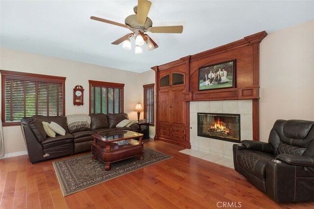 29944 Peach Tree Ct, Murrieta, CA 92563 - living area with light wood-style floors, ceiling fan, healthy amount of natural light, and a fireplace