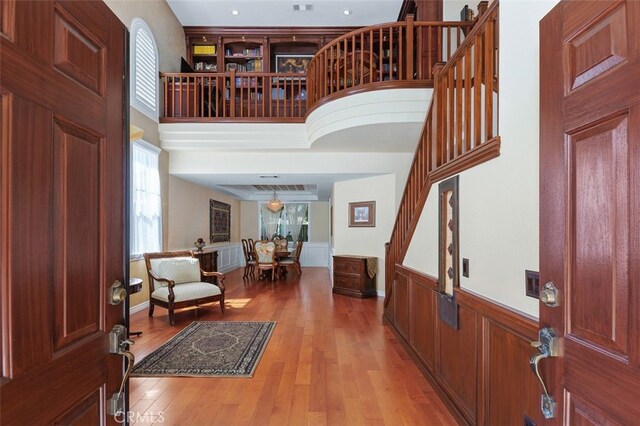 29944 Peach Tree Ct, Murrieta, CA 92563 - entrance foyer featuring light wood finished floors, healthy amount of natural light, a towering ceiling, stairway, and wainscoting