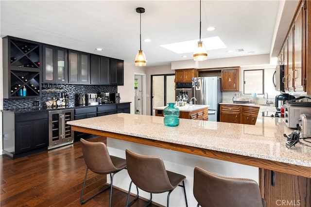 735 Del Valle Dr, Fallbrook, CA 92028 - kitchen with beverage cooler, appliances with stainless steel finishes, brown cabinetry, tasteful backsplash, and recessed lighting