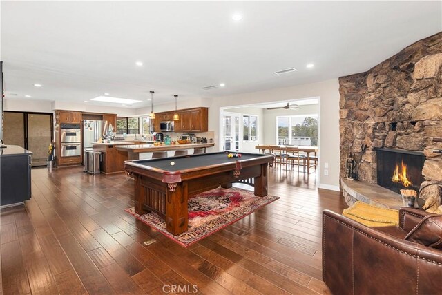 735 Del Valle Dr, Fallbrook, CA 92028 - game room featuring pool table, healthy amount of natural light, dark wood-type flooring, a stone fireplace, and recessed lighting