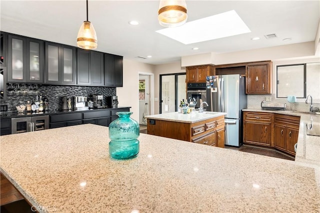 735 Del Valle Dr, Fallbrook, CA 92028 - kitchen featuring stainless steel appliances, a skylight, decorative backsplash, light stone countertops, and recessed lighting
