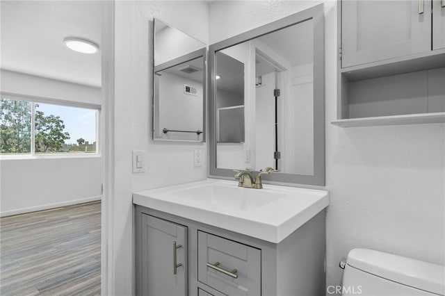 27906 Amber Unit 231, Mission Viejo, CA 92691 - half bathroom with toilet, vanity, wood finished floors, and baseboards