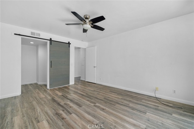 27906 Amber Unit 231, Mission Viejo, CA 92691 - unfurnished bedroom with wood finished floors, a barn door, baseboards, and a ceiling fan