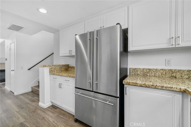 27906 Amber Unit 231, Mission Viejo, CA 92691 - kitchen featuring freestanding refrigerator, light wood finished floors, white cabinetry, light stone counters, and recessed lighting