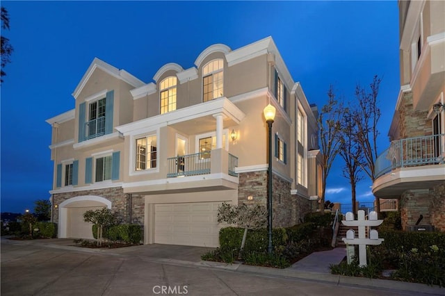 14 Saint Pierre, Newport Coast, CA 92657 - view of front facade with stone siding, stucco siding, and a balcony