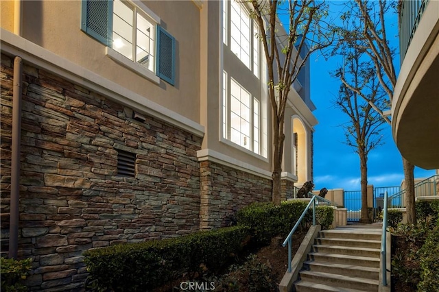 14 Saint Pierre, Newport Coast, CA 92657 - view of home's exterior with stone siding, stairs, and stucco siding