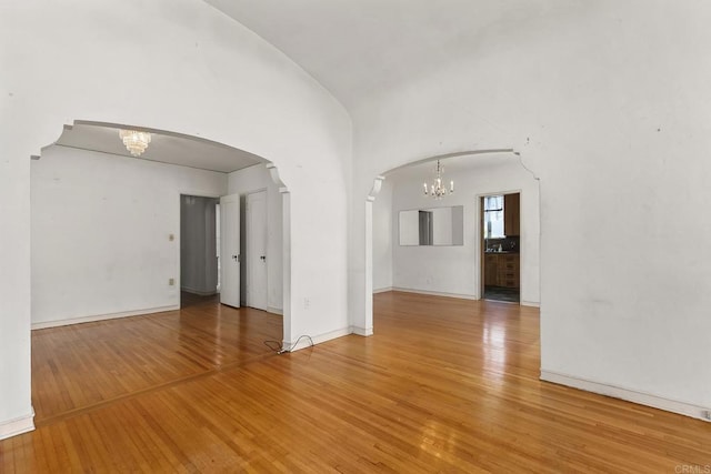 3120 Curtis St, San Diego, CA 92106 - empty room featuring a chandelier, arched walkways, wood finished floors, and baseboards