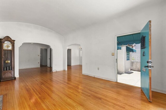 3120 Curtis St, San Diego, CA 92106 - spare room featuring arched walkways, light wood-style floors, vaulted ceiling, and baseboards