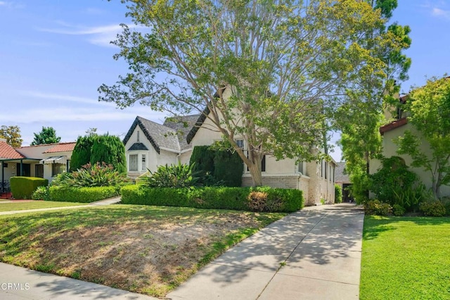1120 S Burnside Ave, Los Angeles, CA 90019 - view of front of home featuring stucco siding, a front yard, and driveway