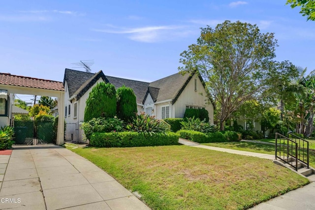 1120 S Burnside Ave, Los Angeles, CA 90019 - view of front of home featuring a gate, a front yard, stucco siding, and a shingled roof