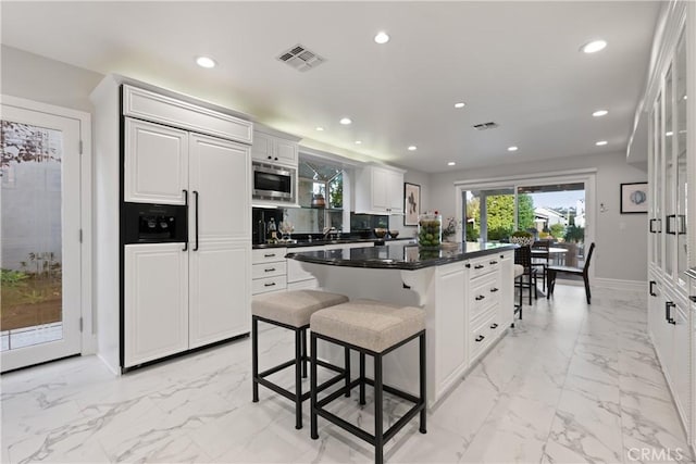 2567 Oakshore, Westlake Village, CA 91361 - kitchen with built in appliances, light marble finish floors, a kitchen island, a breakfast bar, and recessed lighting