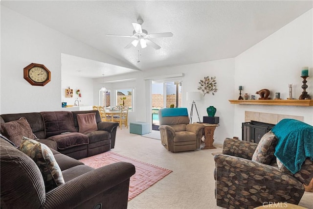 15044 Odell Ct, Victorville, CA 92394 - carpeted living area featuring vaulted ceiling, ceiling fan, a tile fireplace, and a textured ceiling