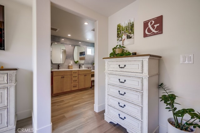 9171 Heatherton Cir, Huntington Beach, CA 92646 - bathroom featuring double vanity, wood finished floors, and recessed lighting
