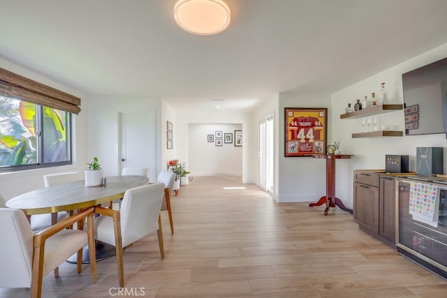 9171 Heatherton Cir, Huntington Beach, CA 92646 - dining area with a bar, light wood-style flooring, and baseboards
