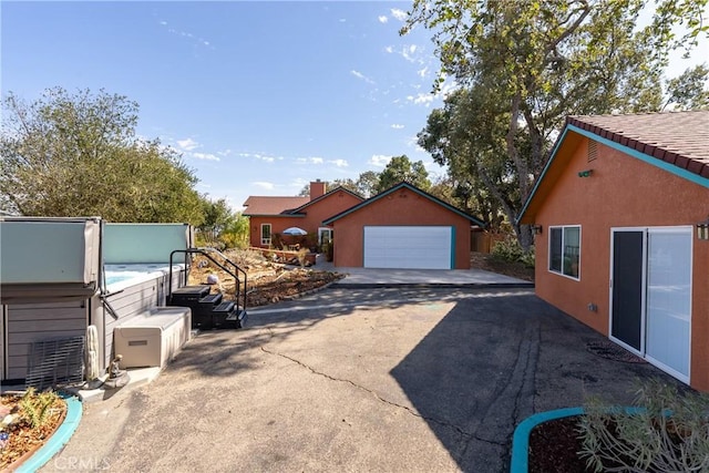 10755 Santa Ana Rd, Atascadero, CA 93422 - view of side of home with a hot tub, a detached garage, stucco siding, and an outbuilding