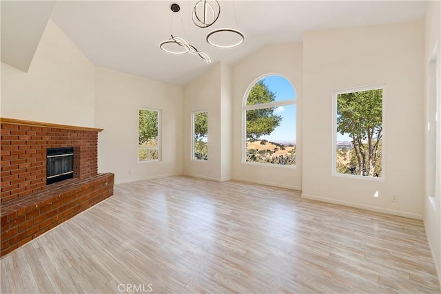 10755 Santa Ana Rd, Atascadero, CA 93422 - unfurnished living room featuring wood finished floors, a chandelier, a fireplace, baseboards, and high vaulted ceiling