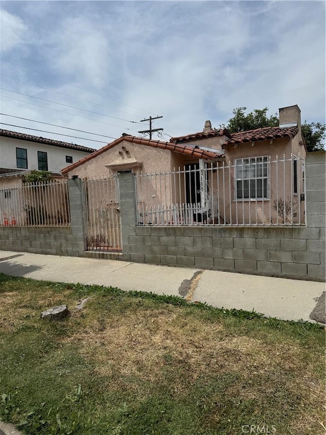 3111 W 57th St, Los Angeles, CA 90043 - view of front facade with a fenced front yard, a tiled roof, stucco siding, and a gate