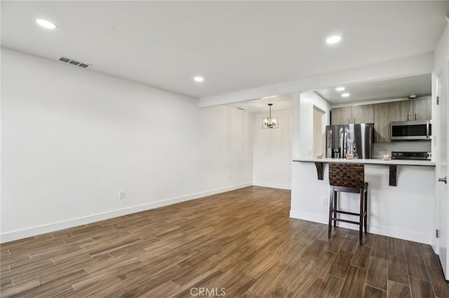 25761 Le Parc Unit 89, Lake Forest, CA 92630 - kitchen with appliances with stainless steel finishes, a breakfast bar area, dark wood finished floors, recessed lighting, and baseboards