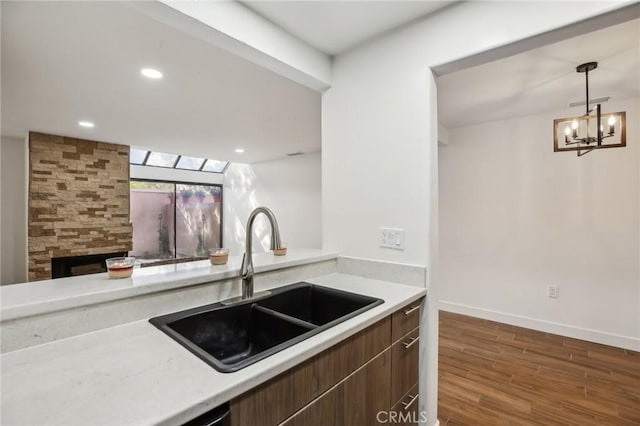 25761 Le Parc Unit 89, Lake Forest, CA 92630 - kitchen with a sink, dark wood-style floors, light countertops, a chandelier, and baseboards