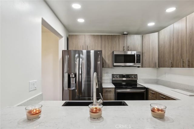 25761 Le Parc Unit 89, Lake Forest, CA 92630 - kitchen featuring stainless steel appliances, a sink, recessed lighting, and light stone countertops