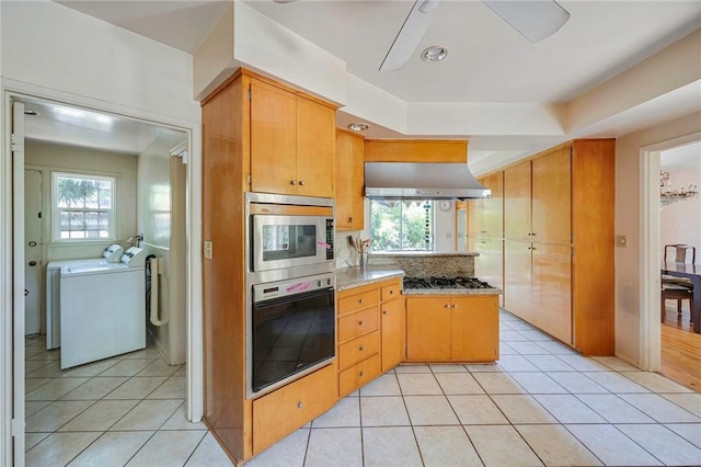 520 Linda Vista Ave, Pasadena, CA 91105 - kitchen with stainless steel appliances, wall chimney range hood, washing machine and dryer, a ceiling fan, and light tile patterned flooring