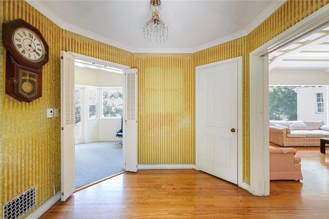 520 Linda Vista Ave, Pasadena, CA 91105 - hallway with wallpapered walls, a chandelier, crown molding, wood finished floors, and baseboards