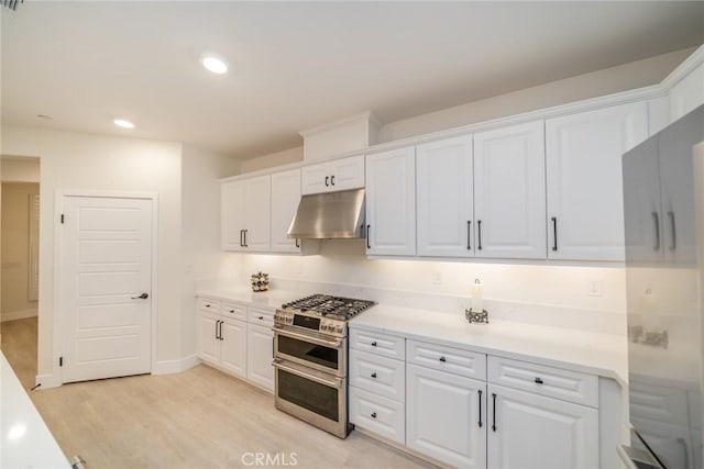 1521 Summerfield Way, Beaumont, CA 92223 - kitchen with under cabinet range hood, range with two ovens, white cabinetry, light countertops, and recessed lighting